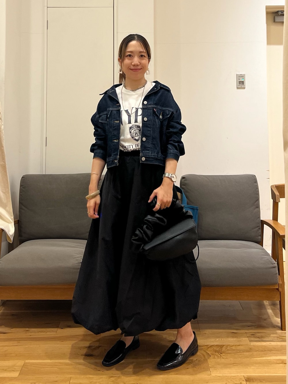 ブルー系のデニムジャケット、ホワイト系のTシャツ/カットソー、ブラック系のスカートを着用したレディースの夏コーディネートの1枚目の写真