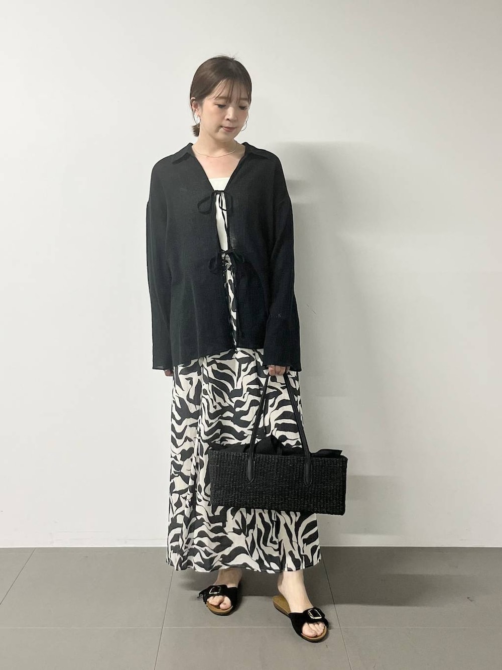 ホワイト系のキャミソール、ブラック系のシャツ/ブラウス、ブラック系のスカートを着用したレディースの春コーディネートの1枚目の写真