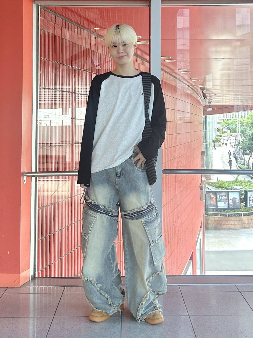 ブラック系のトートバッグ、ブラック系のTシャツ/カットソー、ブルー系のデニムパンツを着用したメンズの秋コーディネートの1枚目の写真