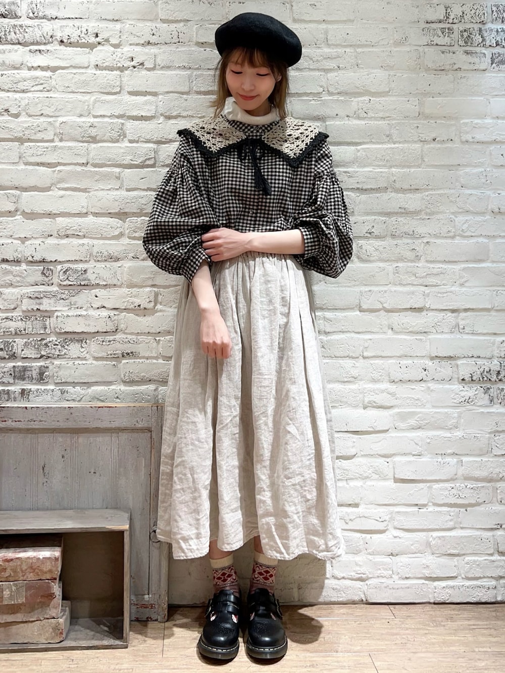 ホワイト系のニット/セーター、ブラック系のチュニック、ホワイト系のスカートを着用したレディースの冬コーディネートの1枚目の写真