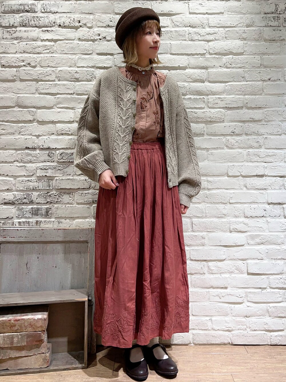 ホワイト系のニット/セーター、ベージュ系のカーディガン/ボレロ、ベージュ系のスカートを着用したレディースの秋コーディネートの1枚目の写真