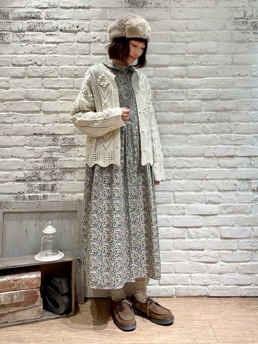 ホワイト系のトップス、ブルー系のワンピース、ベージュ系のドレスシューズを着用したレディースの冬コーディネートの1枚目の写真