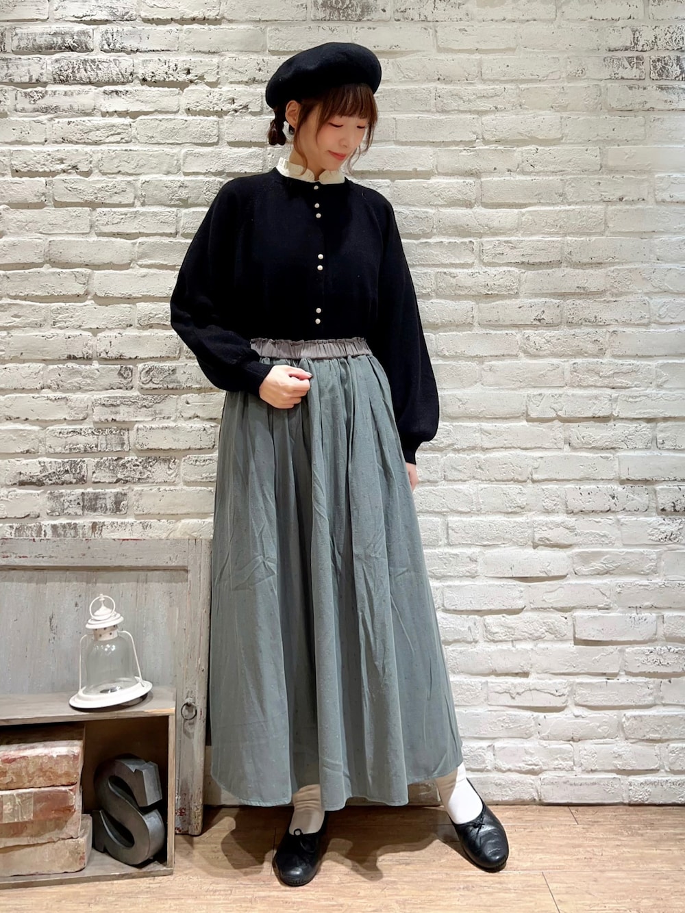 ホワイト系のシャツ/ブラウス、ブラック系のカーディガン/ボレロ、グリーン系のスカートを着用したレディースの秋コーディネートの1枚目の写真