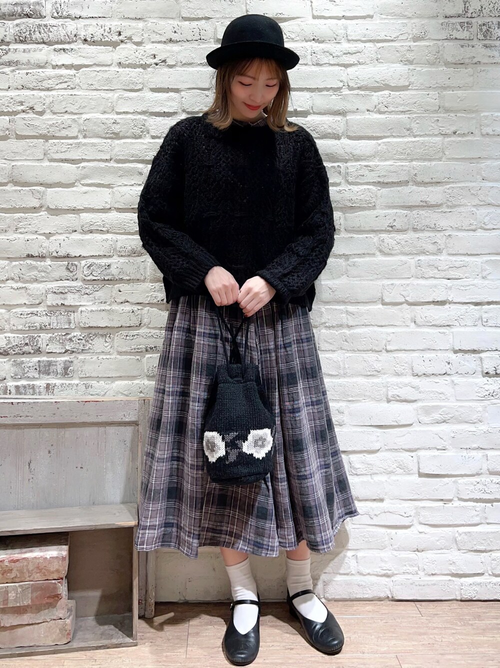 ブラック系のシャツ/ブラウス、ブラック系のニット/セーター、ブラック系のスカートを着用したレディースの冬コーディネートの1枚目の写真
