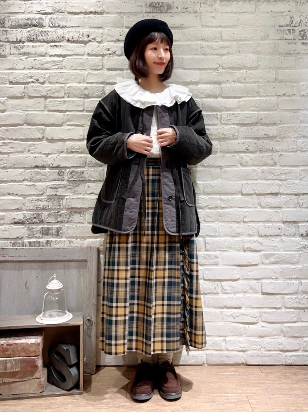 ホワイト系のシャツ/ブラウス、グレー系のノーカラージャケット、グリーン系のスカートを着用したレディースの冬コーディネートの1枚目の写真