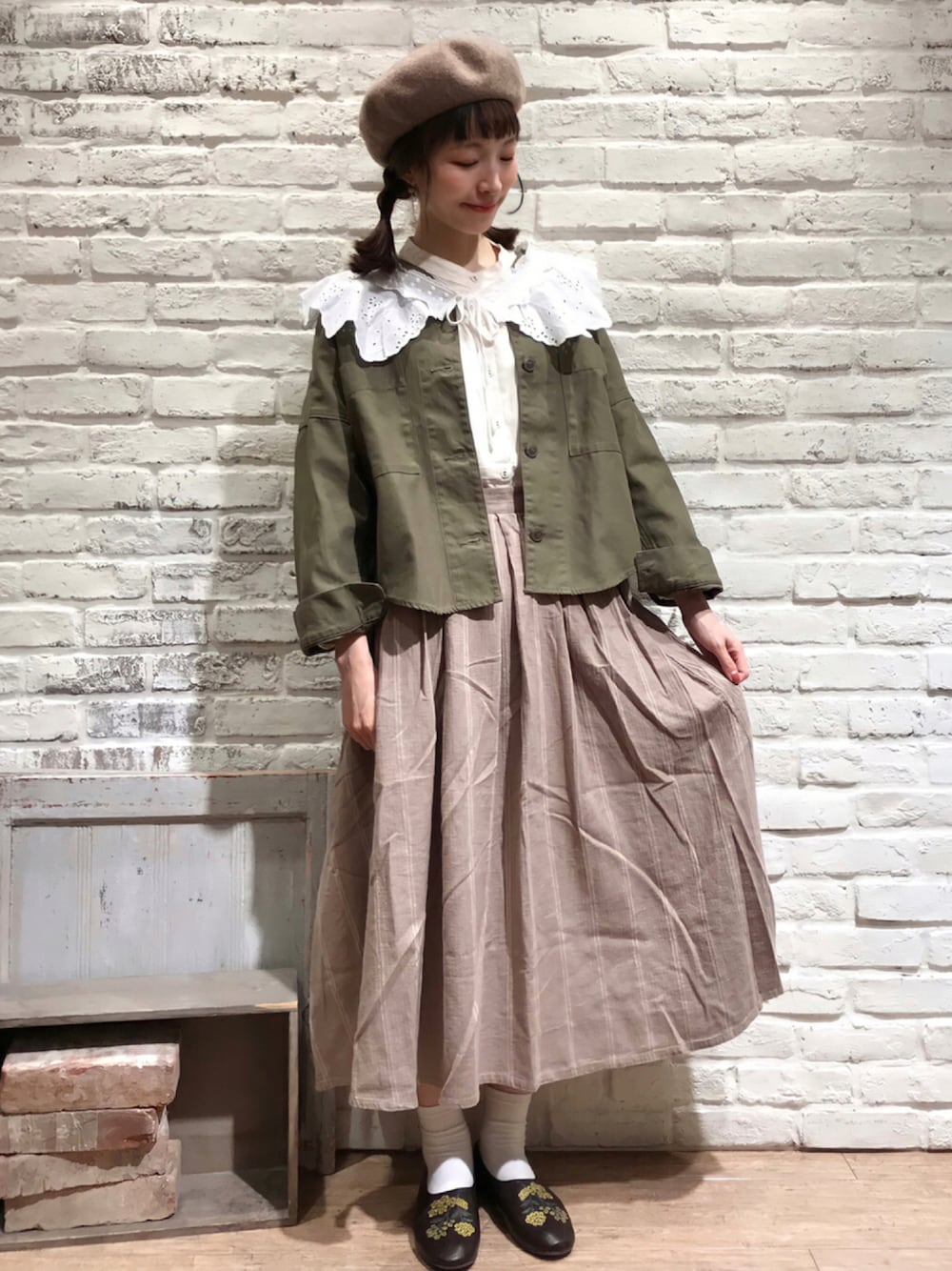 ホワイト系のシャツ/ブラウス、グリーン系のノーカラージャケット、ベージュ系のスカートを着用したレディースの秋コーディネートの1枚目の写真