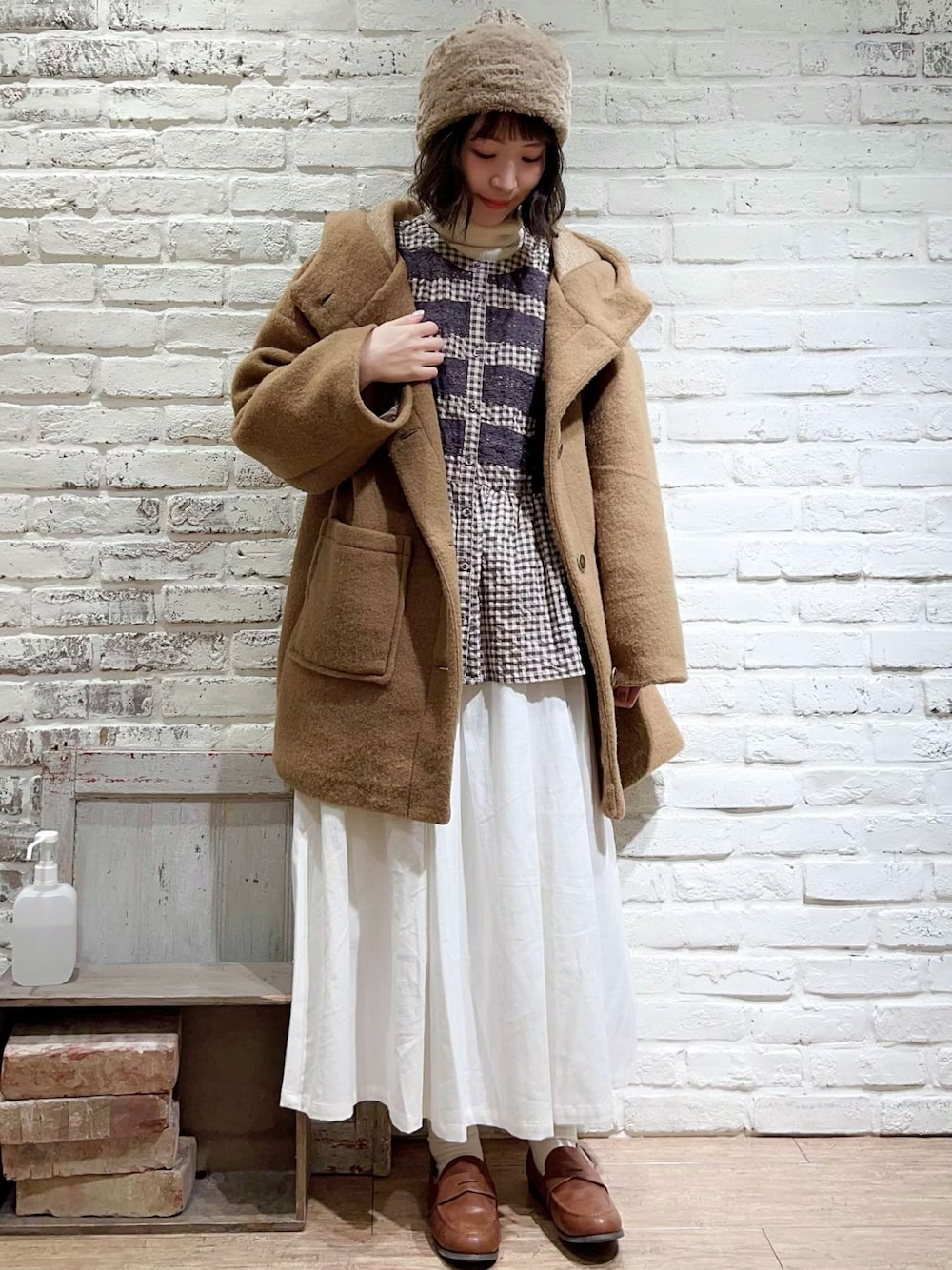 ホワイト系のニット/セーター、イエロー系のその他アウター、グレー系のシャツ/ブラウスを着用したレディースの冬コーディネートの1枚目の写真