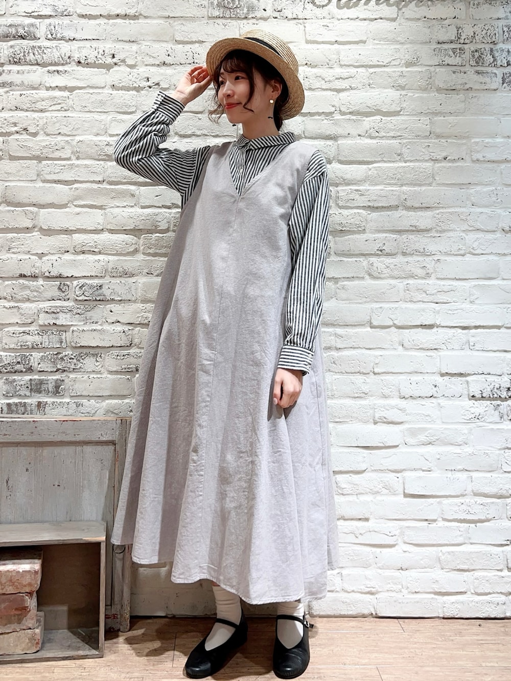 ブラック系のシャツワンピース、ベージュ系のジャンパースカート、ブラック系のドレスシューズを着用したレディースの冬コーディネートの1枚目の写真