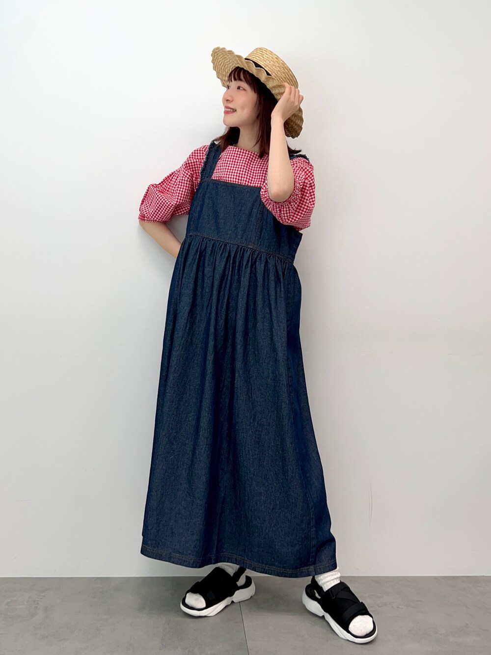 ブラック系のサンダル、レッド系のシャツ/ブラウス、ブルー系のワンピースを着用したレディースの春コーディネートの1枚目の写真