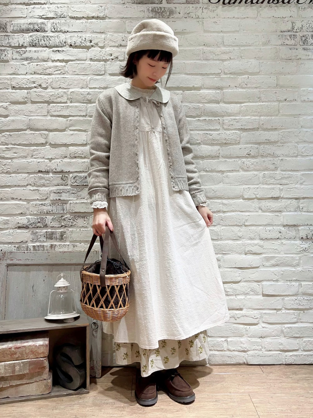 ベージュ系のカーディガン/ボレロ、ホワイト系のワンピース、ブラウン系のハンドバッグを着用したレディースの冬コーディネートの1枚目の写真