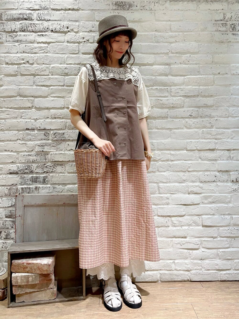 ホワイト系のTシャツ/カットソー、ブラウン系のベスト、ブラウン系のハンドバッグを着用したレディースの秋コーディネートの1枚目の写真