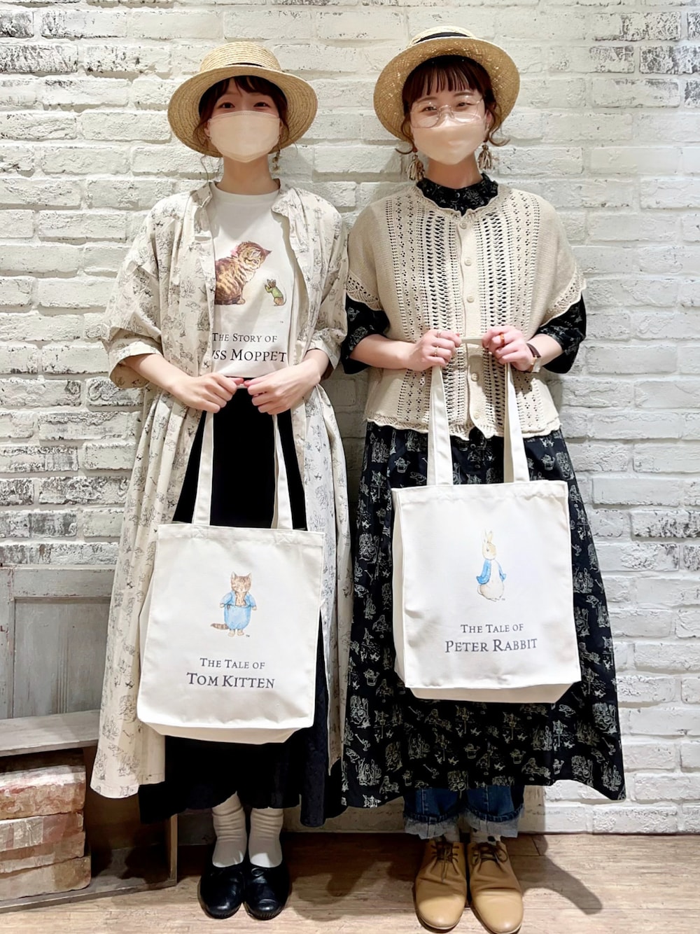 ホワイト系のベスト、ベージュ系のハンドバッグ、ブラック系のワンピースを着用したレディースの夏コーディネートの1枚目の写真