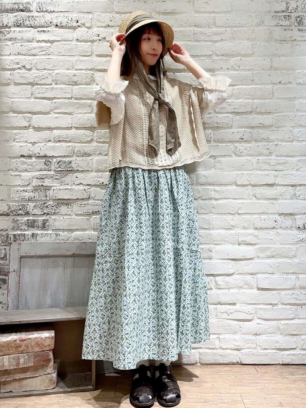 ホワイト系のシャツ/ブラウス、ホワイト系のベスト、グリーン系のスカートを着用したレディースの春コーディネートの1枚目の写真