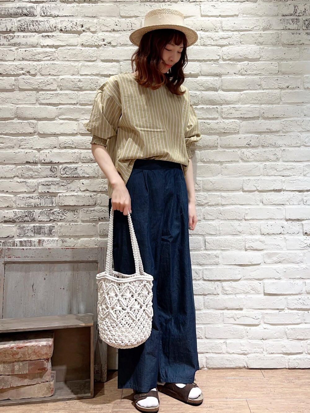 ホワイト系のTシャツ/カットソー、イエロー系のシャツ/ブラウス、ブルー系のデニムパンツを着用したレディースの春コーディネートの1枚目の写真