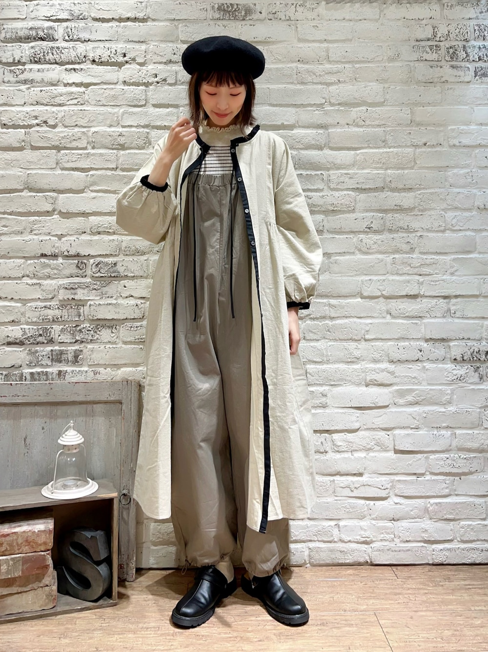 ホワイト系のニット/セーター、ブラウン系のサロペット/オーバーオール、ブラック系のサンダルを着用したレディースの冬コーディネートの1枚目の写真