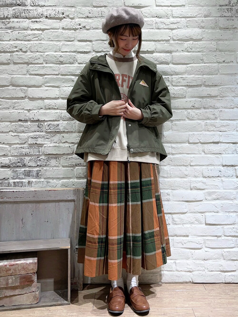 ホワイト系のシャツ/ブラウス、グリーン系のマウンテンパーカー、ホワイト系のTシャツ/カットソーを着用したレディースの秋コーディネートの1枚目の写真