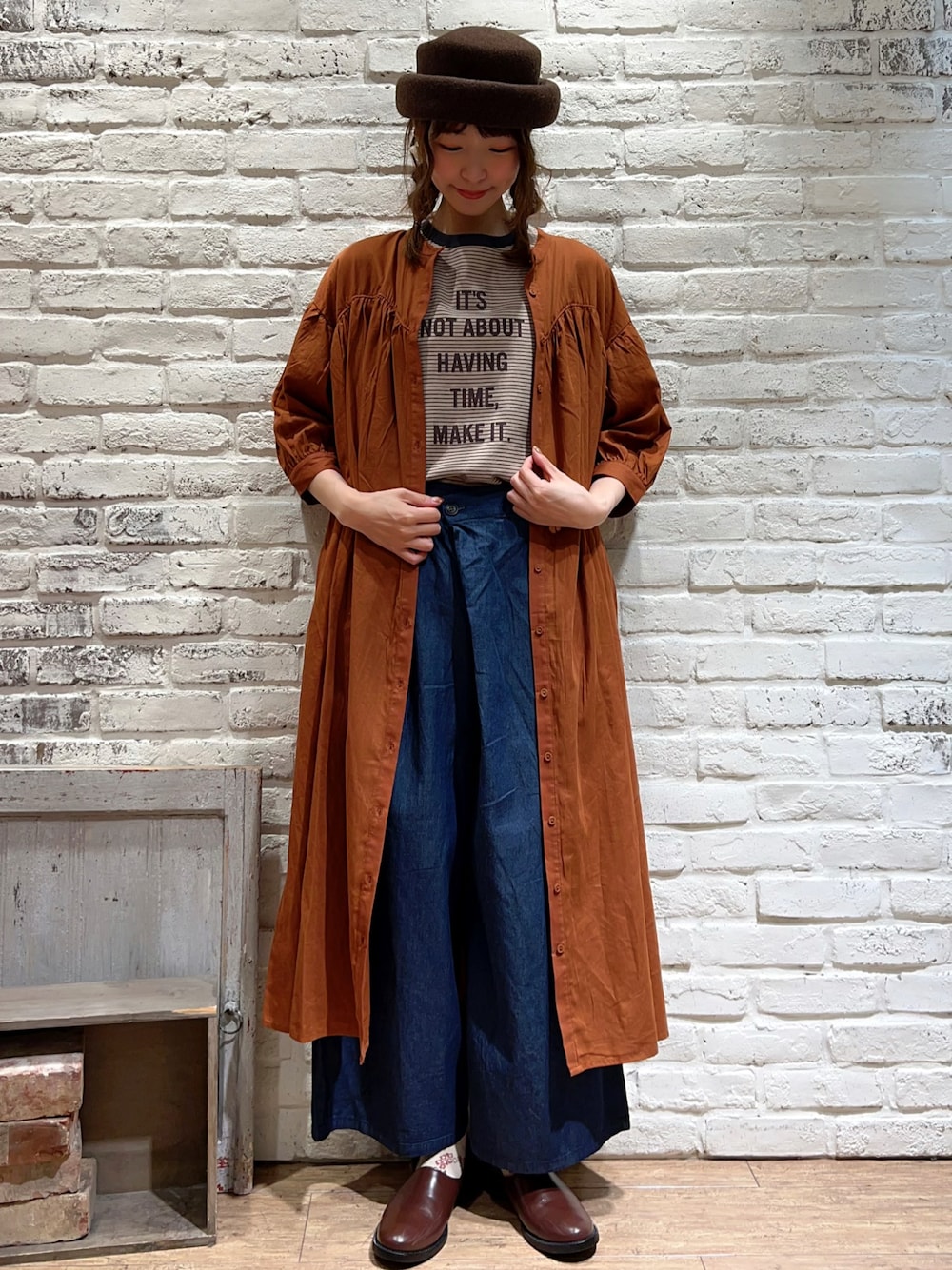 ベージュ系のTシャツ/カットソー、オレンジ系のワンピース、ブルー系のデニムパンツを着用したレディースの夏コーディネートの1枚目の写真