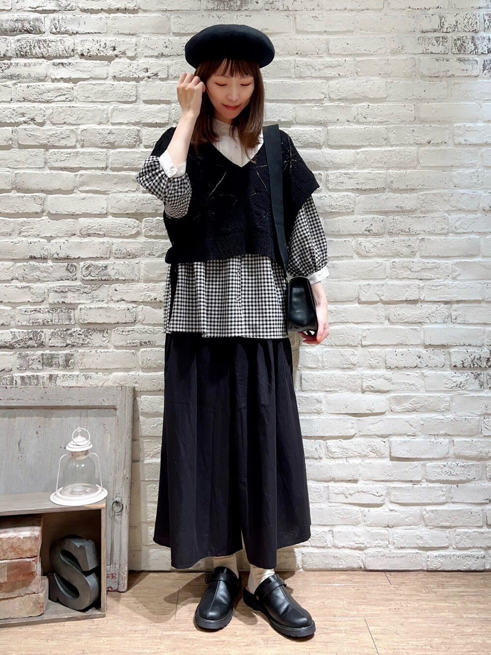 ブラック系のベスト、ブラック系のシャツ/ブラウス、ブラック系のハンドバッグを着用したレディースの秋コーディネートの1枚目の写真