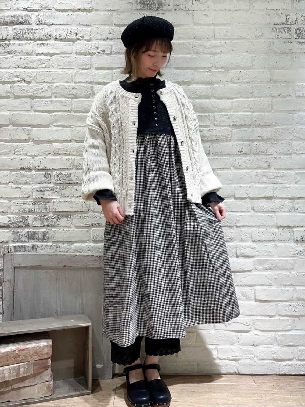 ブラック系のシャツ/ブラウス、ホワイト系のカーディガン/ボレロ、ブラック系のドレスシューズを着用したレディースの冬コーディネートの1枚目の写真