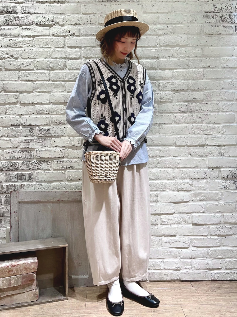 ブルー系のシャツ/ブラウス、ホワイト系のベスト、ブラック系のハンドバッグを着用したレディースの春コーディネートの1枚目の写真