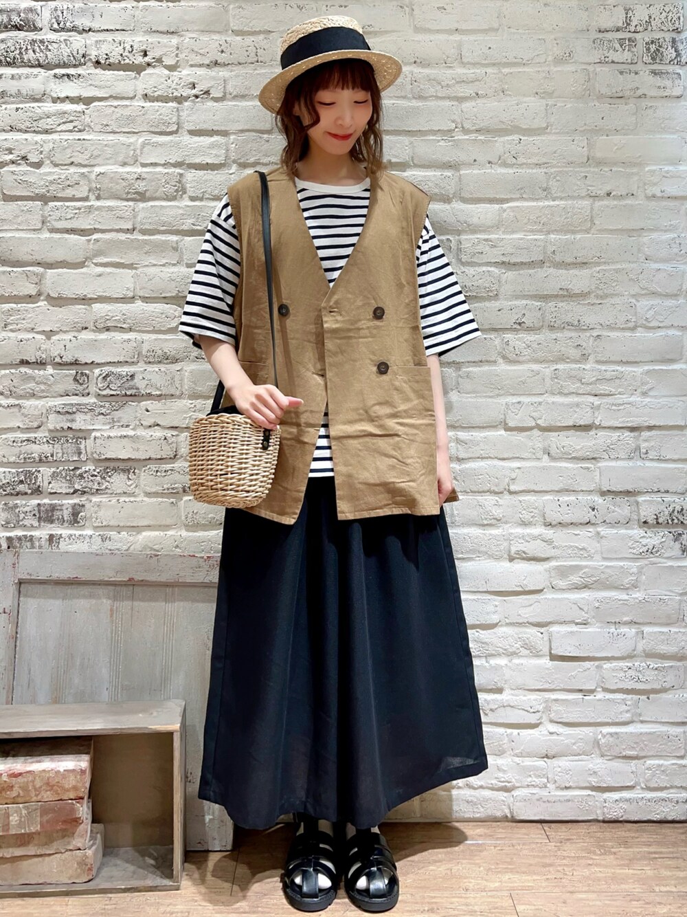 ホワイト系のTシャツ/カットソー、ベージュ系のベスト、ブラック系のハンドバッグを着用したレディースの春コーディネートの1枚目の写真