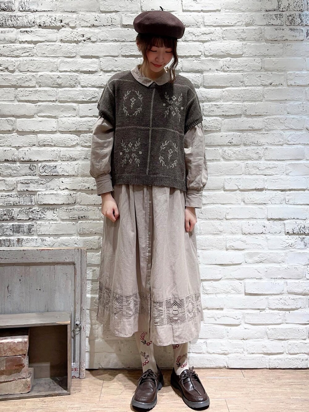 ブラウン系のベスト、ベージュ系のワンピース、ブラウン系のその他シューズを着用したレディースの秋コーディネートの1枚目の写真