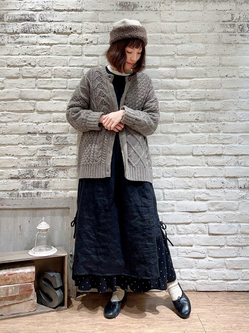 ホワイト系のTシャツ/カットソー、ブラウン系のカーディガン/ボレロ、ブラック系のワンピースを着用したレディースの冬コーディネートの1枚目の写真