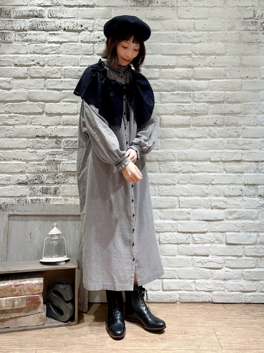 ブラック系のスカート、グレー系のワンピース、ブラック系のシューズを着用したレディースの冬コーディネートの1枚目の写真