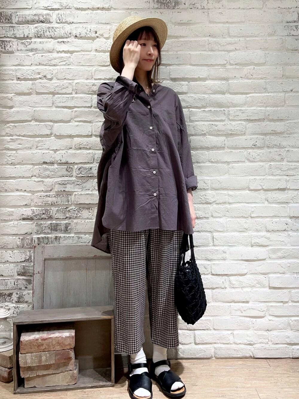 ブラック系のタンクトップ、グレー系のシャツ/ブラウス、ブラック系のハンドバッグを着用したレディースの春コーディネートの1枚目の写真