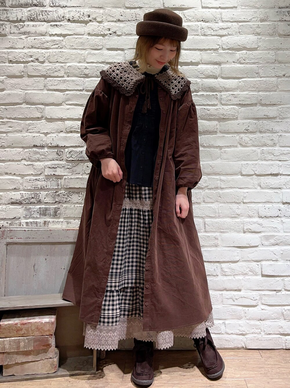 ホワイト系のニット/セーター、ブラック系のシャツ/ブラウス、ブラウン系のワンピースを着用したレディースの秋コーディネートの1枚目の写真