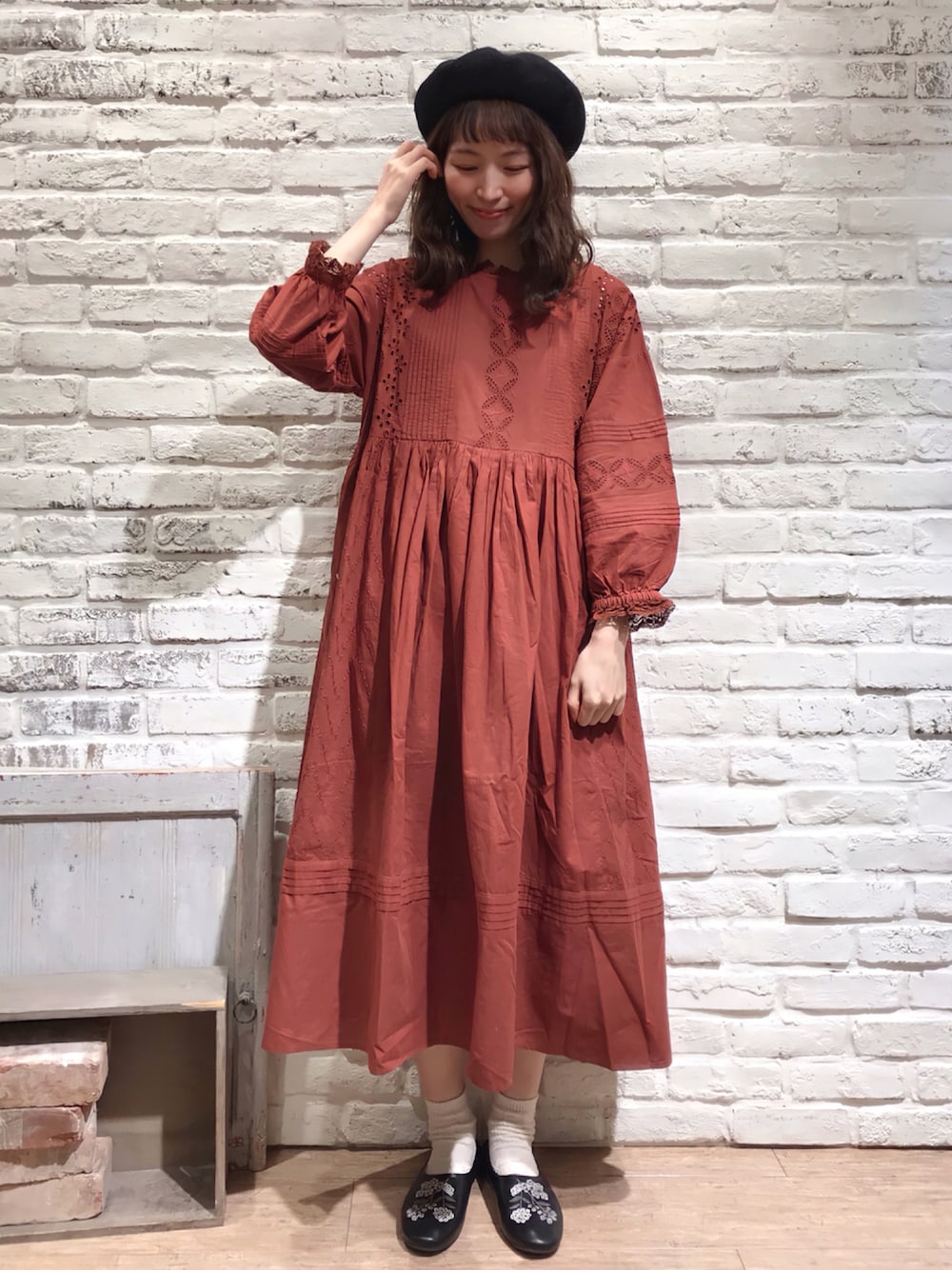 ブラウン系のニット/セーター、レッド系のワンピース、ブラック系のその他シューズを着用したレディースの秋コーディネートの1枚目の写真