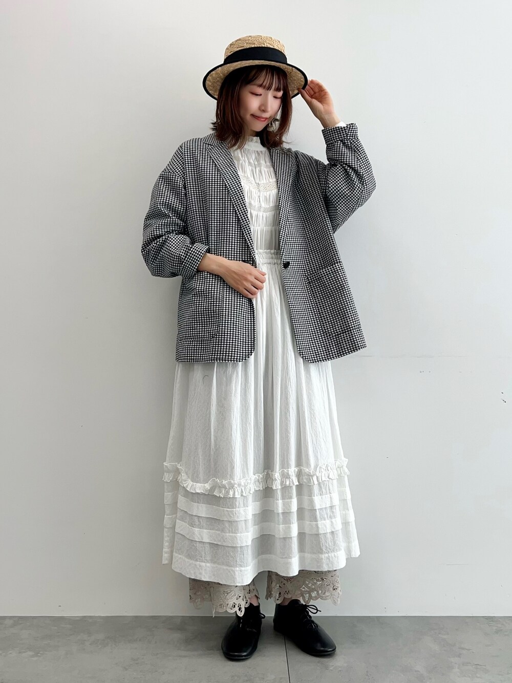 ホワイト系のシャツ/ブラウス、ブラック系のノーカラージャケット、ホワイト系のスカートを着用したレディースの春コーディネートの1枚目の写真