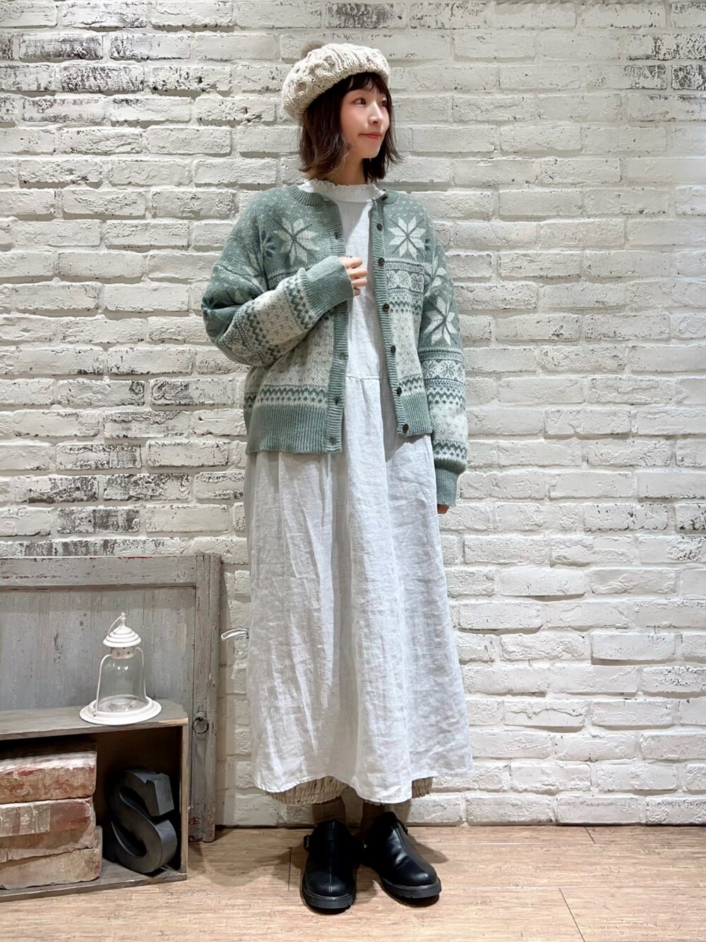 ホワイト系のTシャツ/カットソー、グリーン系のカーディガン/ボレロ、グリーン系のワンピースを着用したレディースの冬コーディネートの1枚目の写真