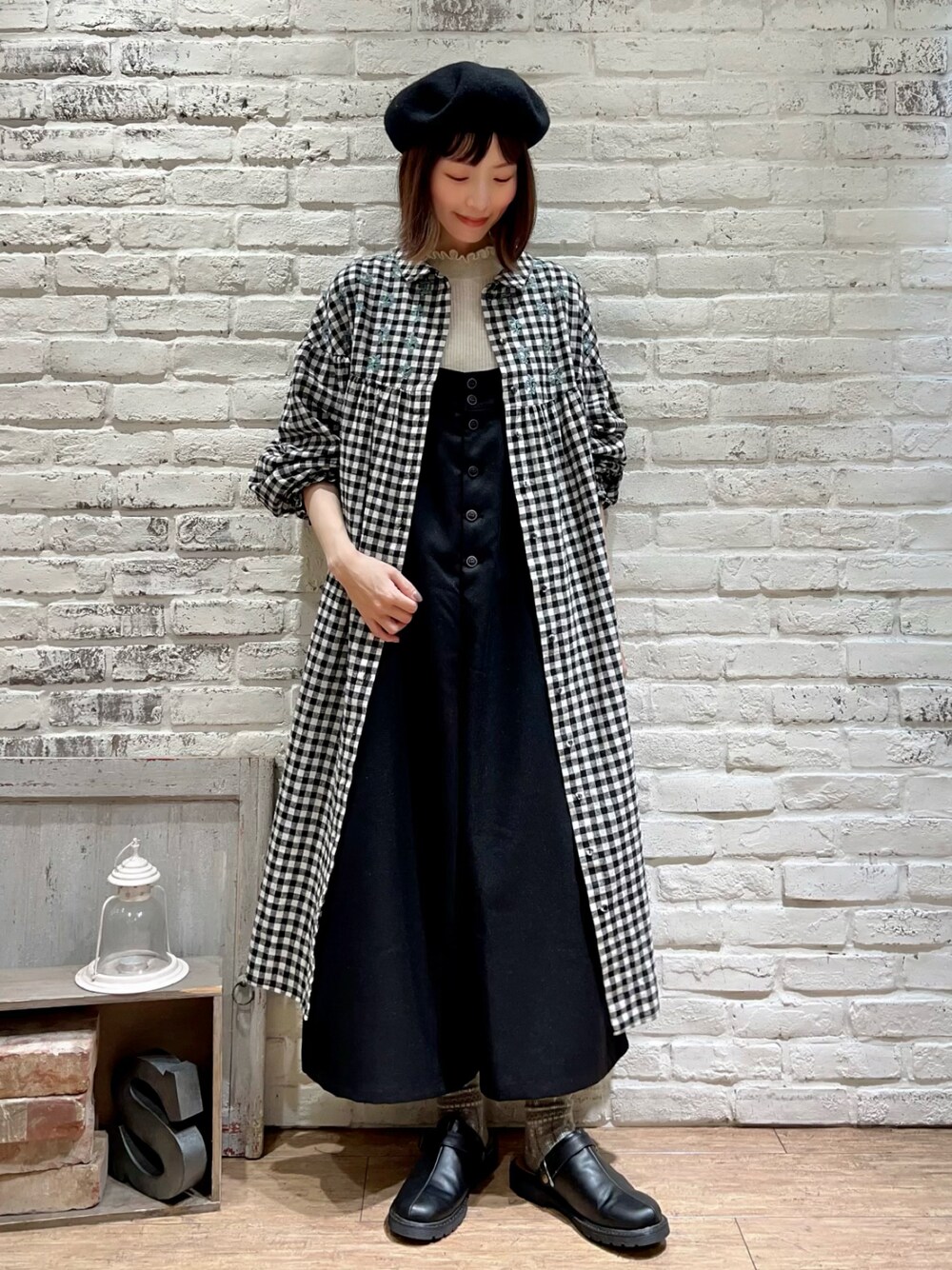 ホワイト系のニット/セーター、ブルー系のワンピース、ブラック系のサロペット/オーバーオールを着用したレディースの冬コーディネートの1枚目の写真