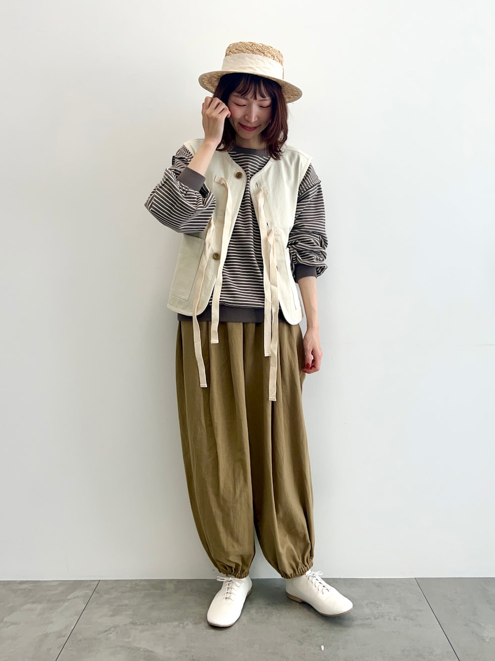 ホワイト系のベスト、ブラウン系のTシャツ/カットソー、ベージュ系のその他パンツを着用したレディースの春コーディネートの1枚目の写真