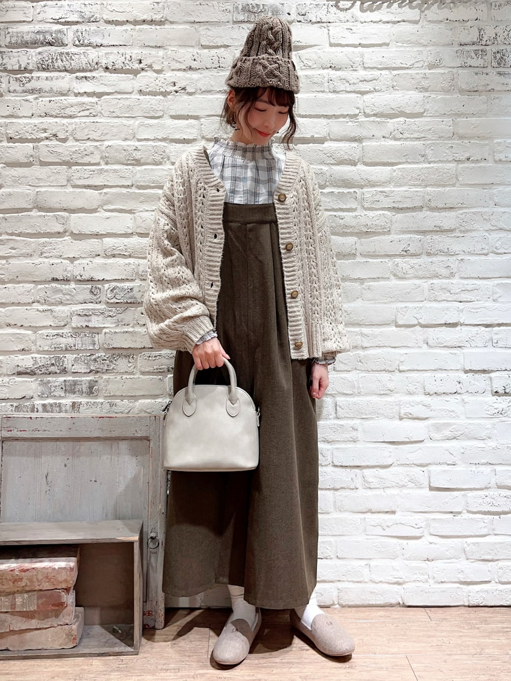 ホワイト系のシャツ/ブラウス、ベージュ系のニット/セーター、ブラウン系のサロペット/オーバーオールを着用したレディースの冬コーディネートの1枚目の写真
