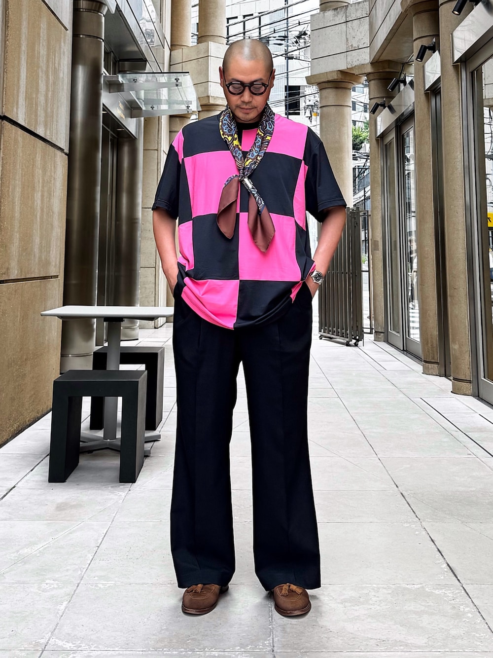 ブラック系のスラックス、ブラウン系のその他シューズ、ピンク系のTシャツ/カットソーを着用したメンズの夏コーディネートの1枚目の写真