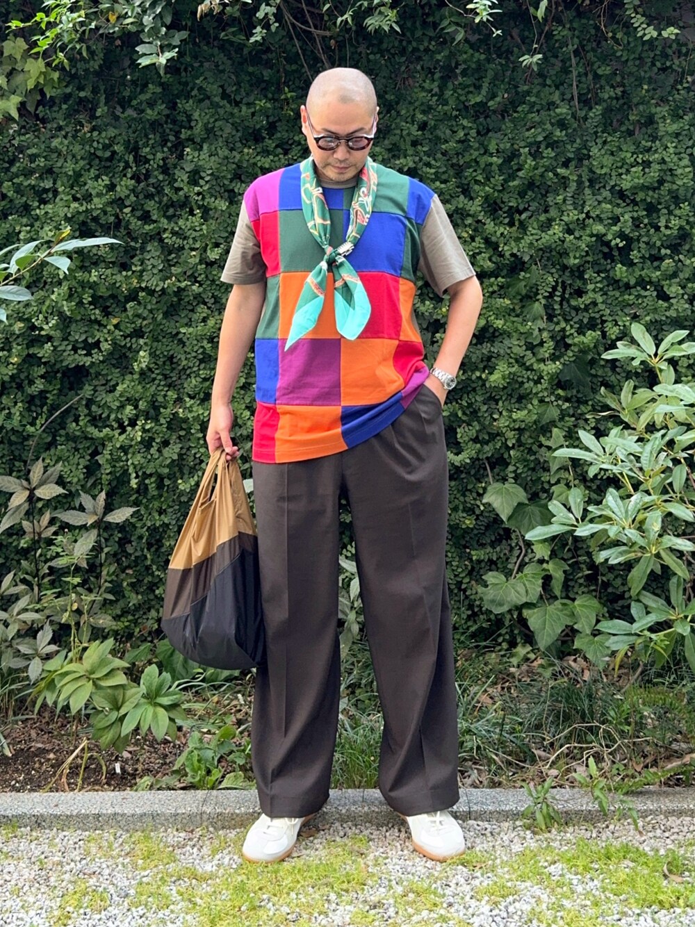 ブラウン系のスラックス、ホワイト系のスニーカー、その他のTシャツ/カットソーを着用したメンズの秋コーディネートの1枚目の写真