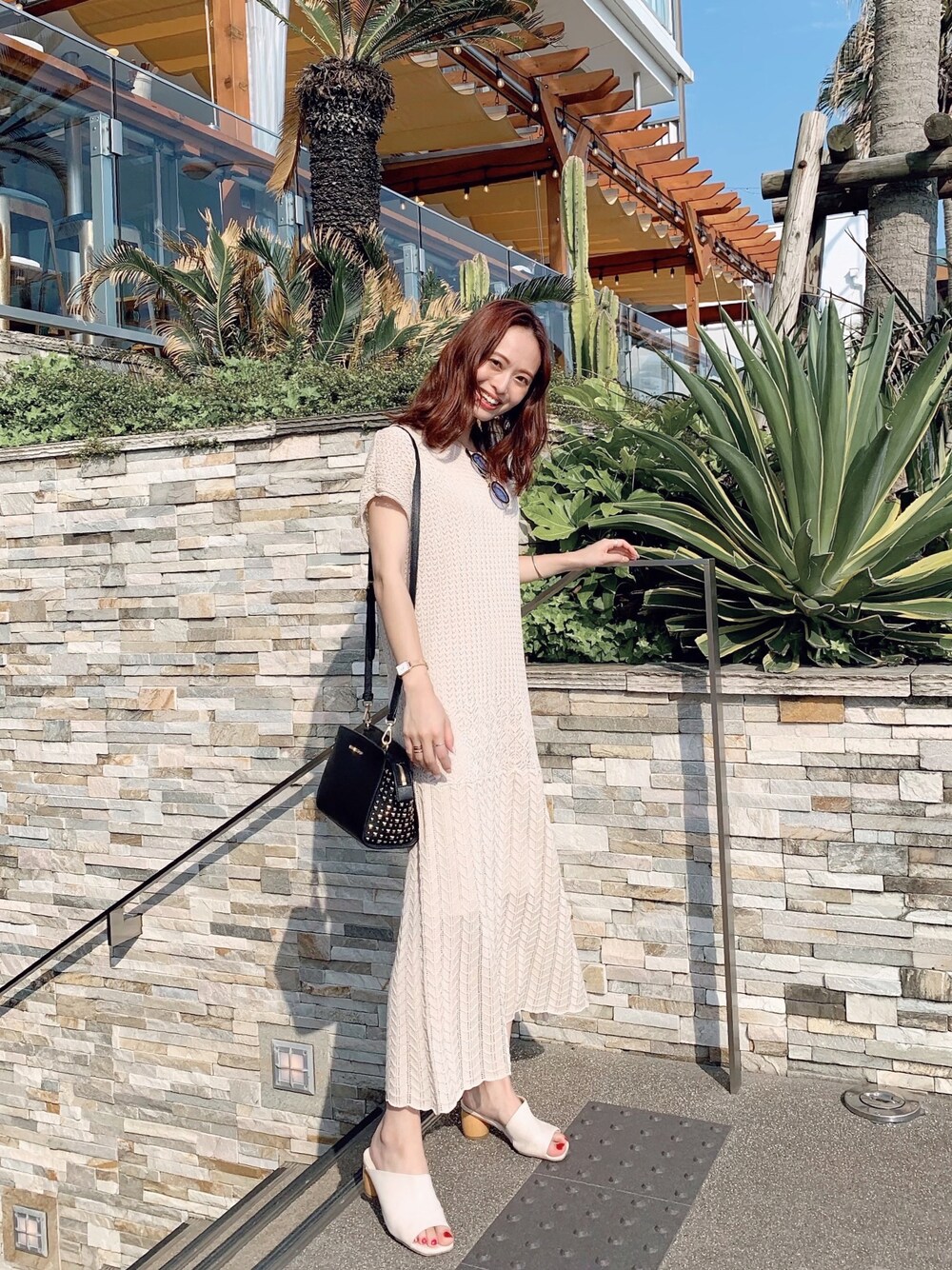 ベージュ系のワンピース/ドレス、ブラック系のバッグ、ホワイト系のサンダルを着用したレディースの秋コーディネートの1枚目の写真