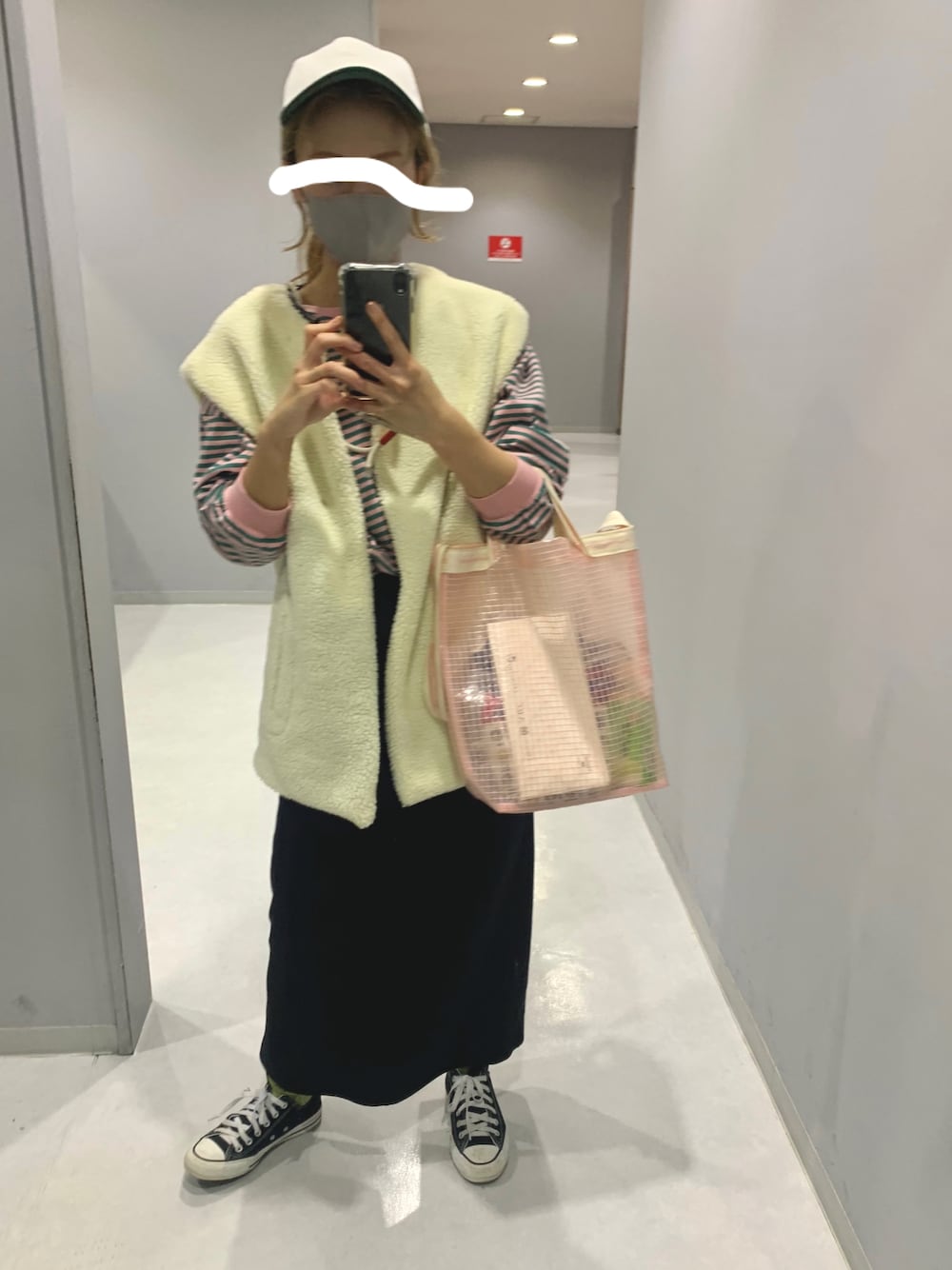 ブラック系のベスト、ピンク系のショルダーバッグ、ブラック系のスカートを着用したレディースの秋コーディネートの1枚目の写真