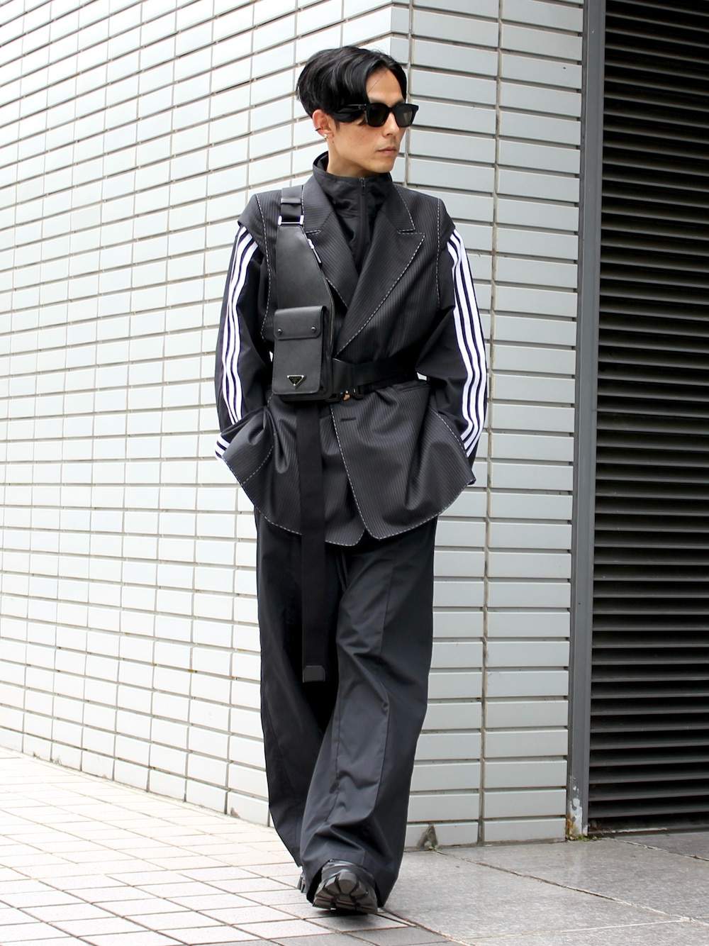 グレー系のテーラードジャケット、ブラック系のボディバッグ/ウエストポーチ、ブラック系のスニーカーを着用したメンズの春コーディネートの1枚目の写真