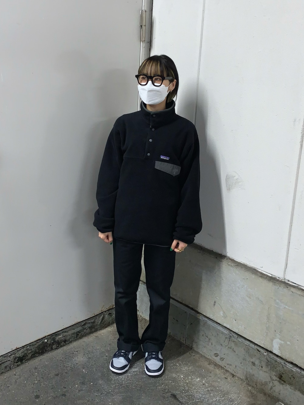 ブラック系のトップス、ブラック系のチノパンツ、グレー系のスニーカーを着用したレディースの秋コーディネートの1枚目の写真