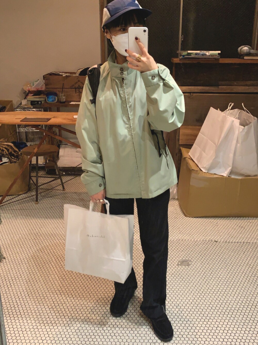 グリーン系のブルゾン、ブラック系のチノパンツ、ブラック系のローファーを着用したレディースの秋コーディネートの1枚目の写真