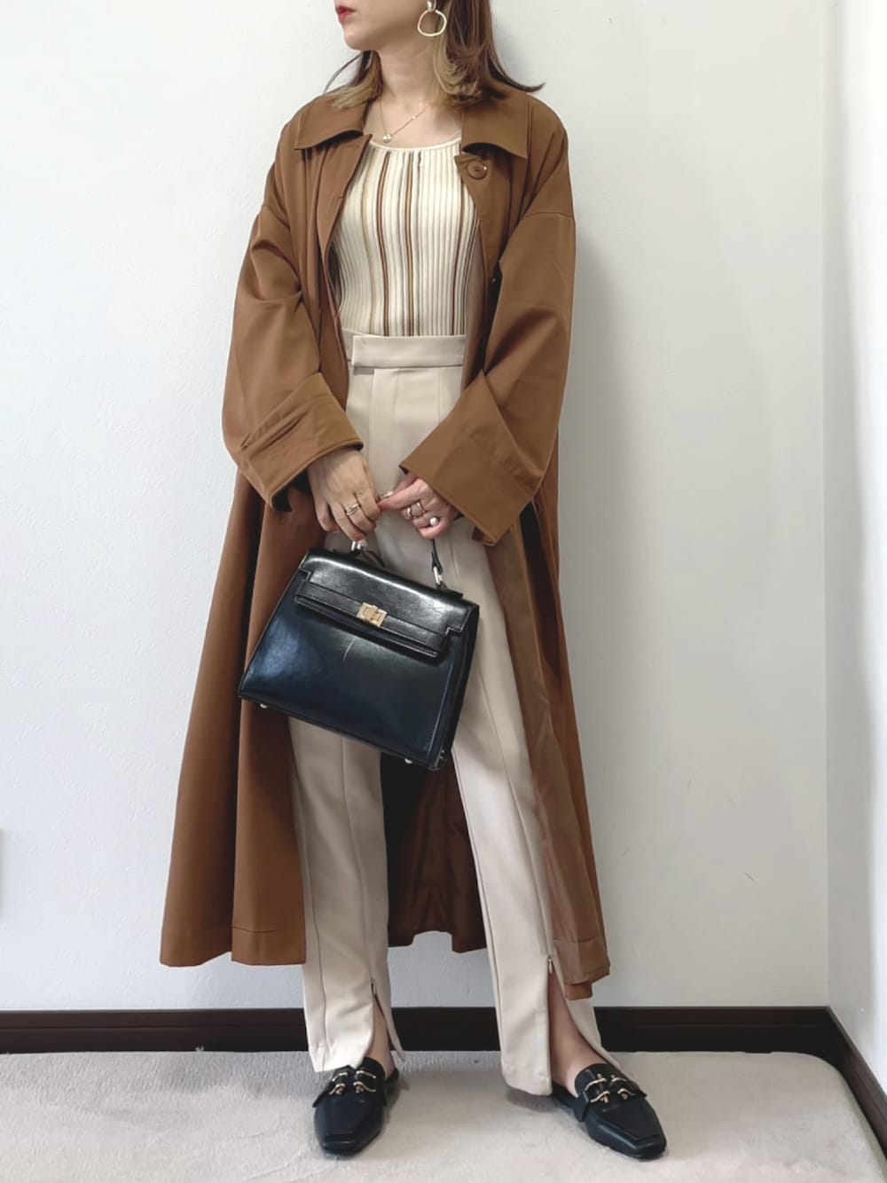 ベージュ系のタンクトップ、ブラック系のハンドバッグ、ブラック系のローファーを着用したレディースの夏コーディネートの1枚目の写真