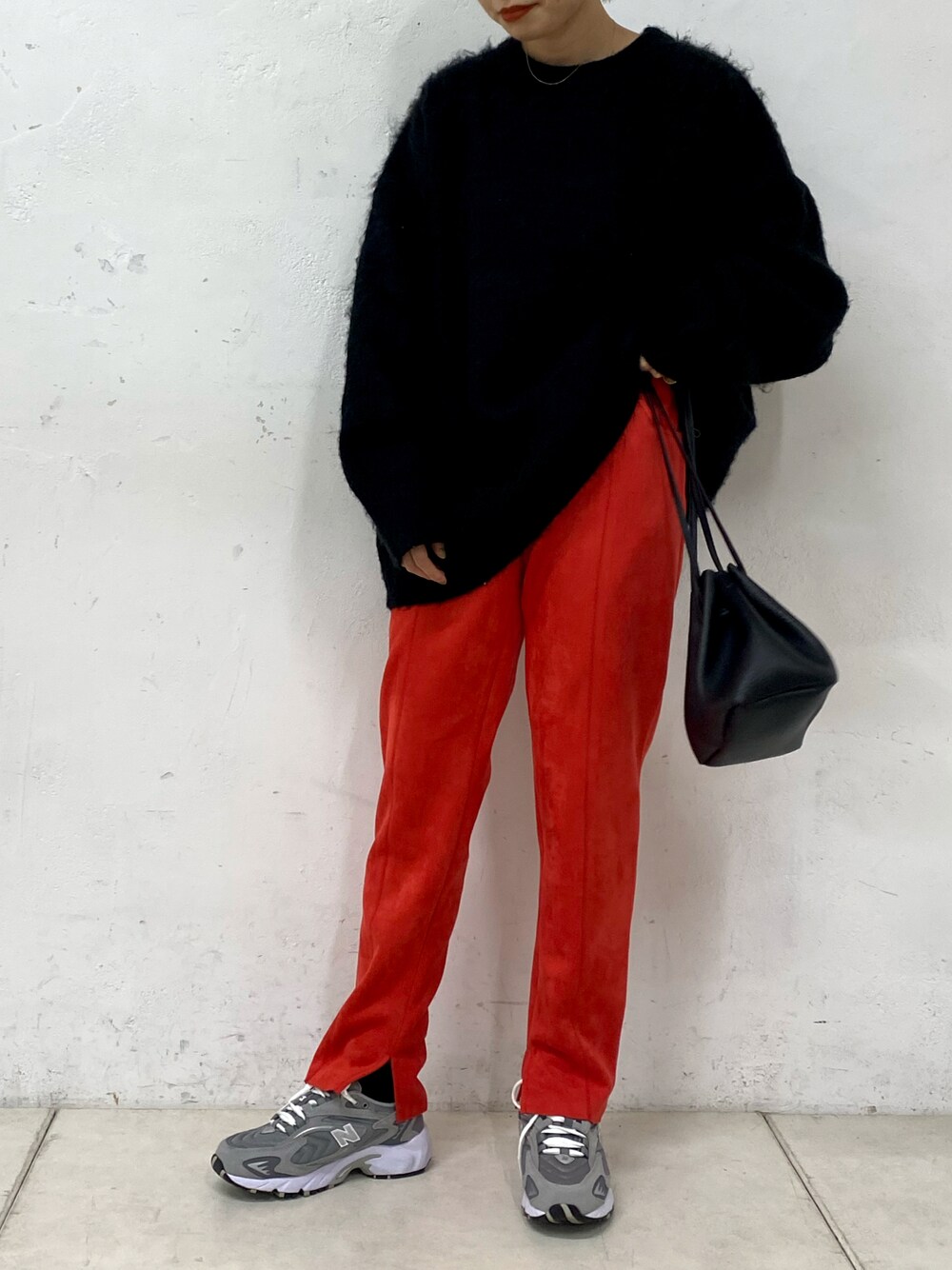 ブラック系のショルダーバッグ、ブラック系のニット/セーター、レッド系のその他パンツを着用したレディースの冬コーディネートの1枚目の写真