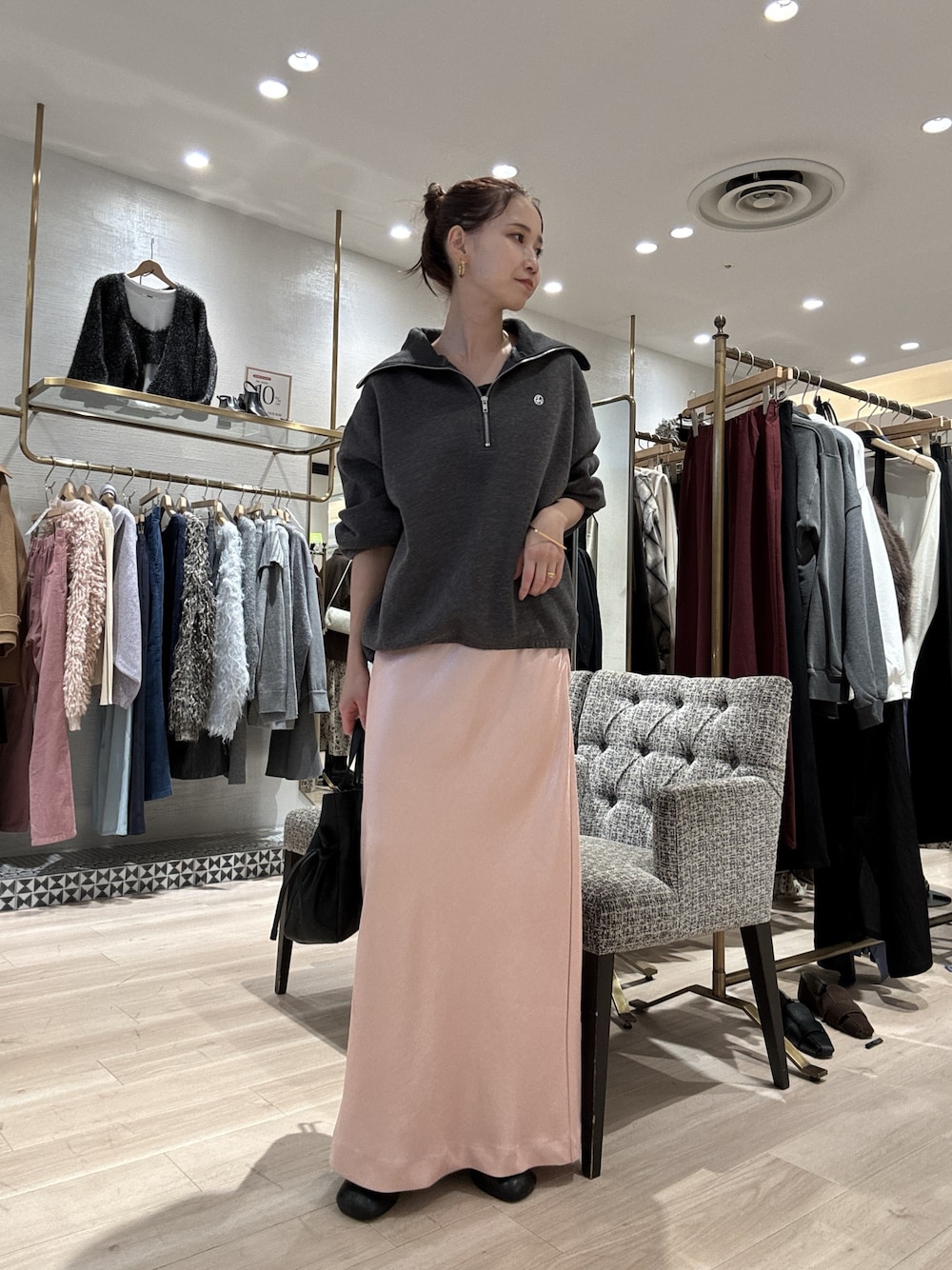 グレー系のスウェット、ピンク系のスカート、ブラック系のショルダーバッグを着用したレディースの秋コーディネートの1枚目の写真