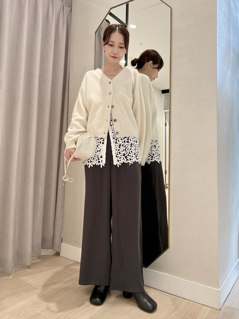 ホワイト系のカーディガン/ボレロ、ホワイト系のキャミソール、グレー系のその他パンツを着用したレディースの秋コーディネートの1枚目の写真