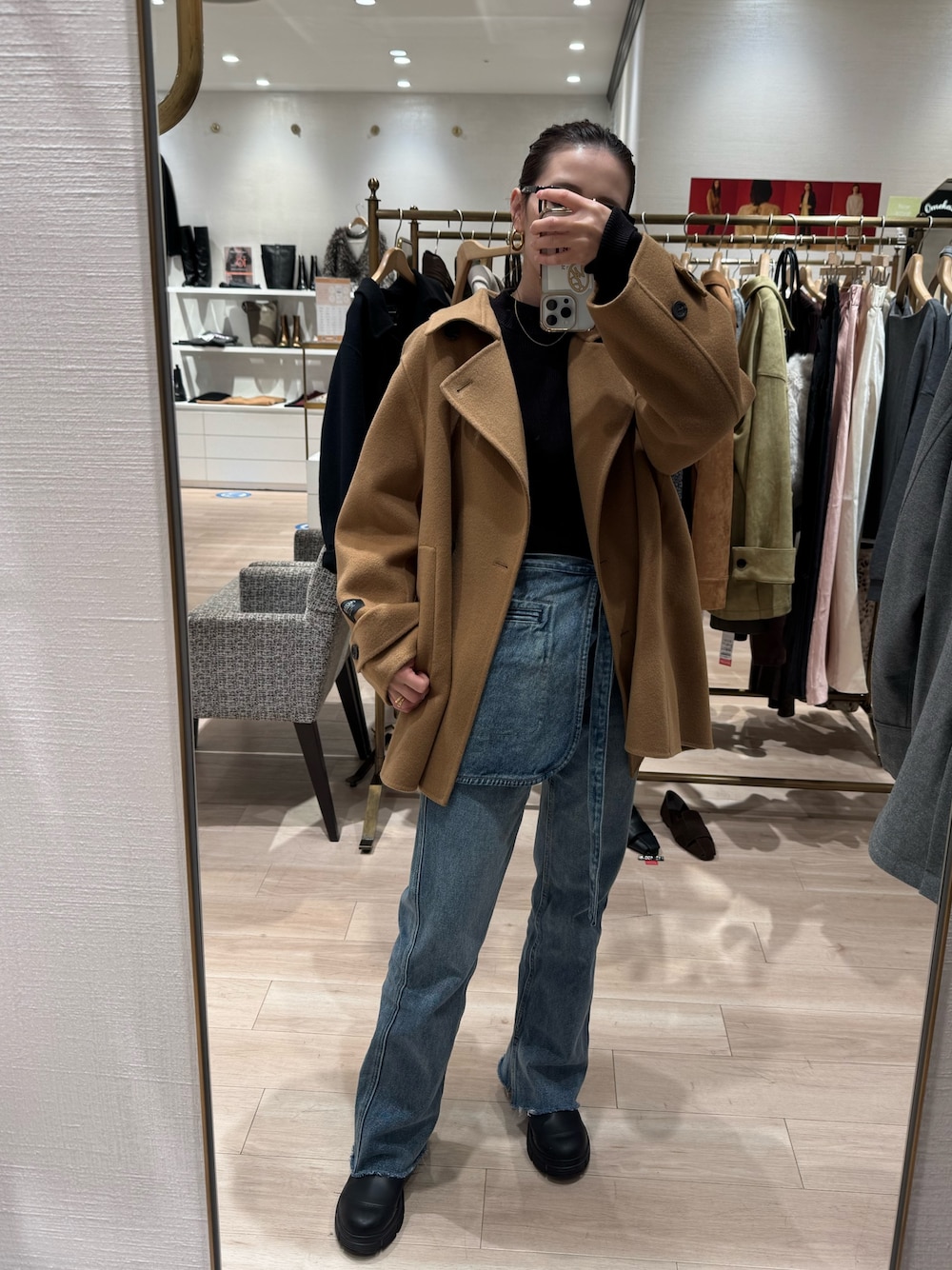 イエロー系のピーコート、ブルー系のデニムパンツを着用したレディースの秋コーディネートの1枚目の写真