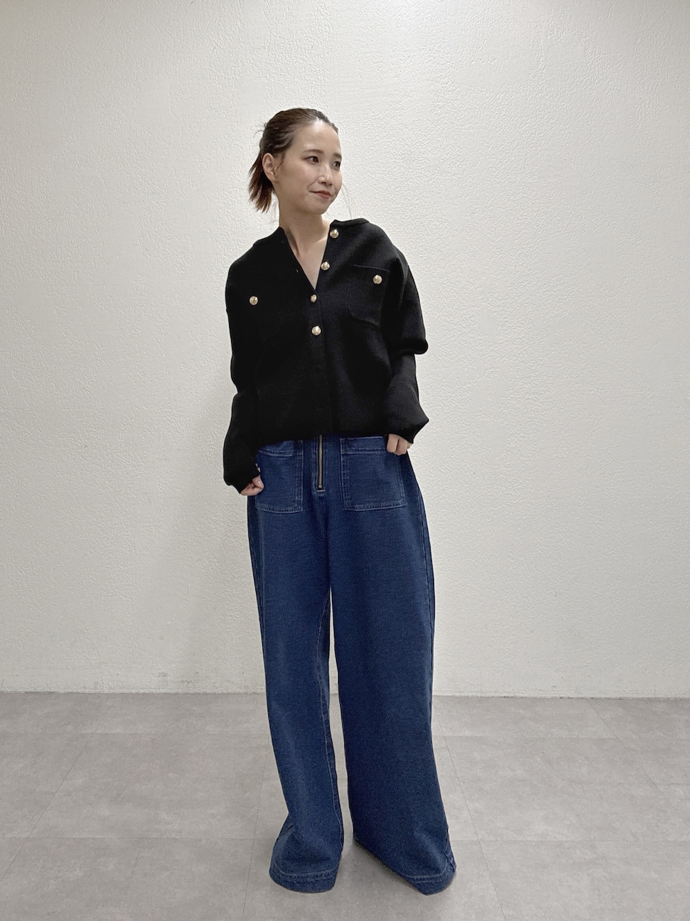 ブルー系のデニムパンツ、ブラック系のカーディガン/ボレロを着用したレディースの秋コーディネートの1枚目の写真