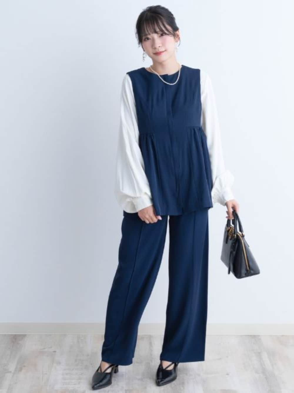 ブラック系のスーツセット、ホワイト系のシャツ/ブラウス、ブルー系のマタニティウェア/グッズを着用したレディースの秋コーディネートの1枚目の写真